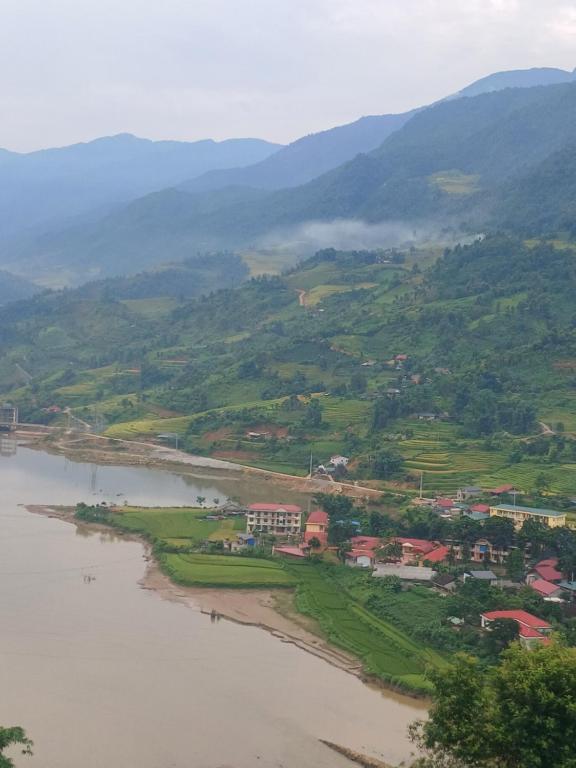 uma vista para um rio com montanhas ao fundo em Family homestay mrhieu em Lao Cai