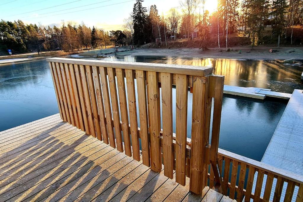 a wooden deck with a view of a body of water at Cozy Beach Cabin - close to city center in Pargas