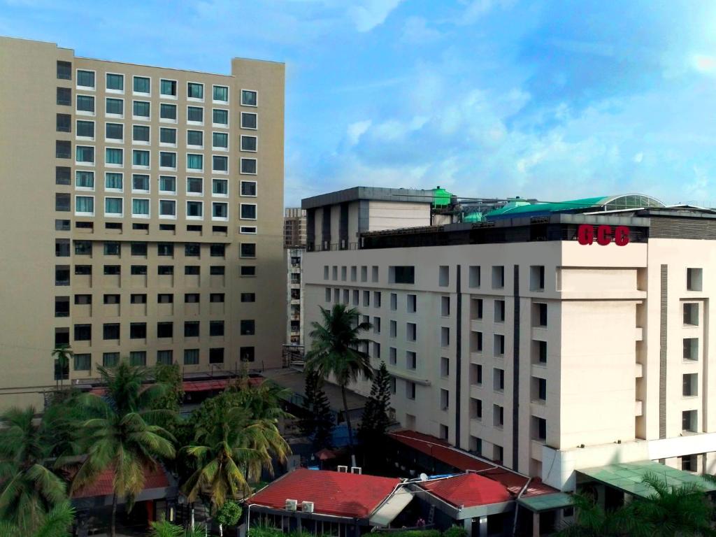 a group of buildings in a city with palm trees at GCC Hotel and Club in Mumbai