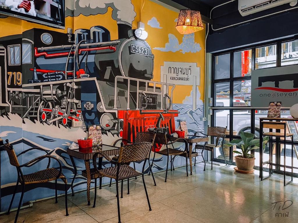 a restaurant with a mural of a train on the wall at 107 Hostel (One-O-Seven Hostel) in Kanchanaburi City