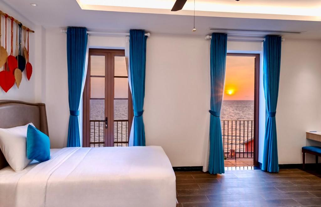 sypialnia z łóżkiem i widokiem na ocean w obiekcie Roma Hotel Phu Quoc - Free Hon Thom Island Waterpark Cable Car w Duong Dong