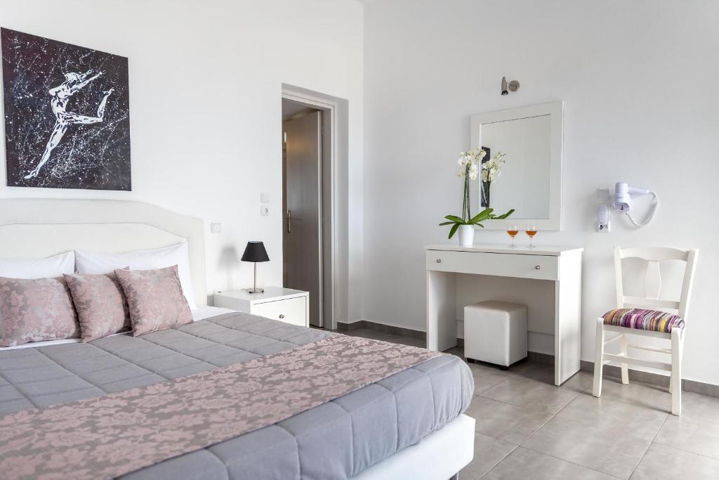 1 dormitorio con cama, escritorio y silla en Aigli Villa en Fira