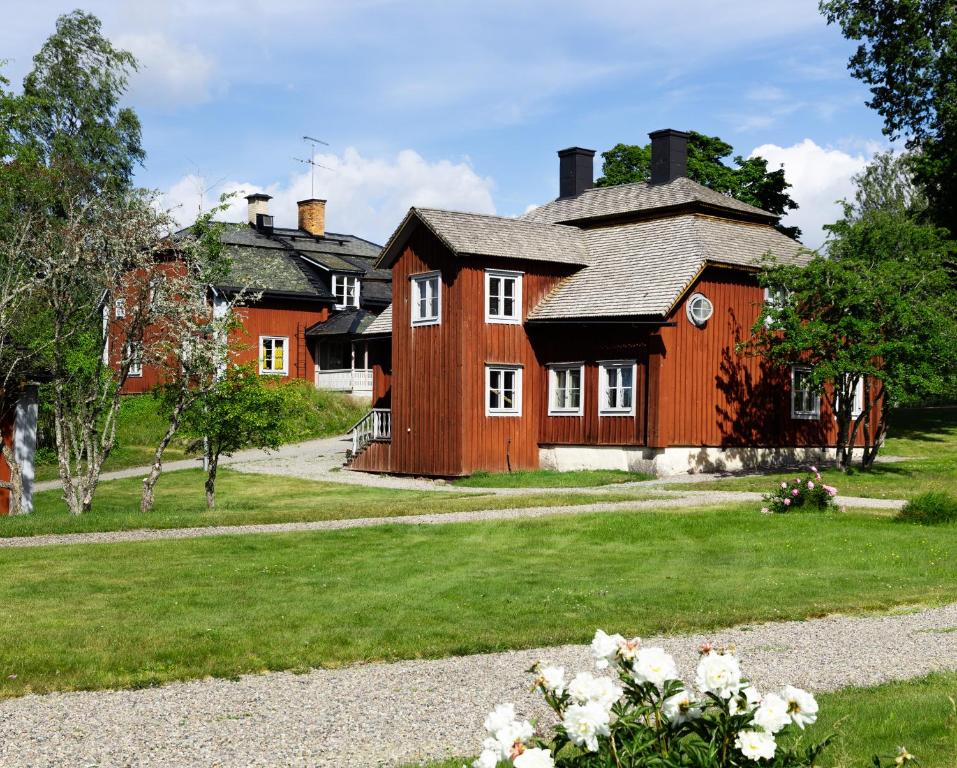 uma grande casa de madeira com janelas brancas e um quintal em Professorsvillan - hyr hela huset em Malingsbo