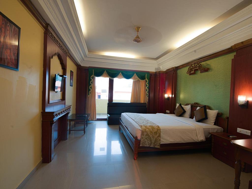 Habitación de hotel con cama y TV. en NRS Royal Palace, en Puri