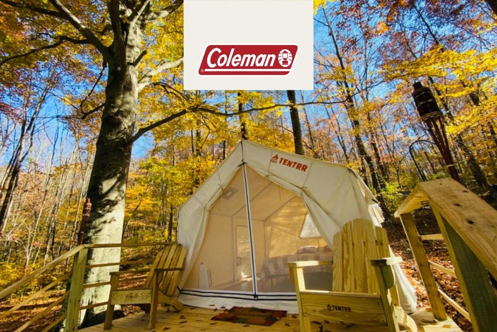 a tent in the woods with a sign above it at Tentrr Signature Site - Huff Farm in Maryville