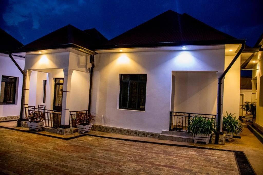 B I G Residence Hotel في بوجومبورا: منزل أبيض مع شرفة في الليل