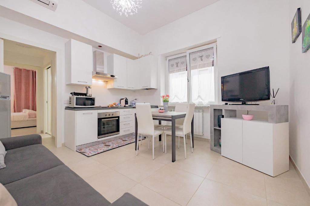 een keuken en een woonkamer met een tafel en een televisie bij La casa di Alessia nel centro di Como - Alessiatravelling in Como