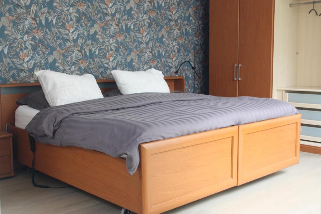 a bedroom with a wooden bed with two pillows at tisOKE in Vught