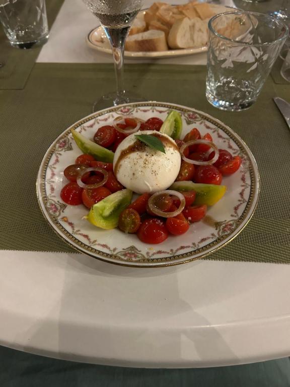 a plate of food with tomatoes and an egg on a table at Auberge U Mulinu in Casalabriva
