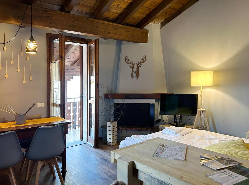 a bedroom with a bed and a desk and a television at La Corte della Casera in Cassina Valsassina