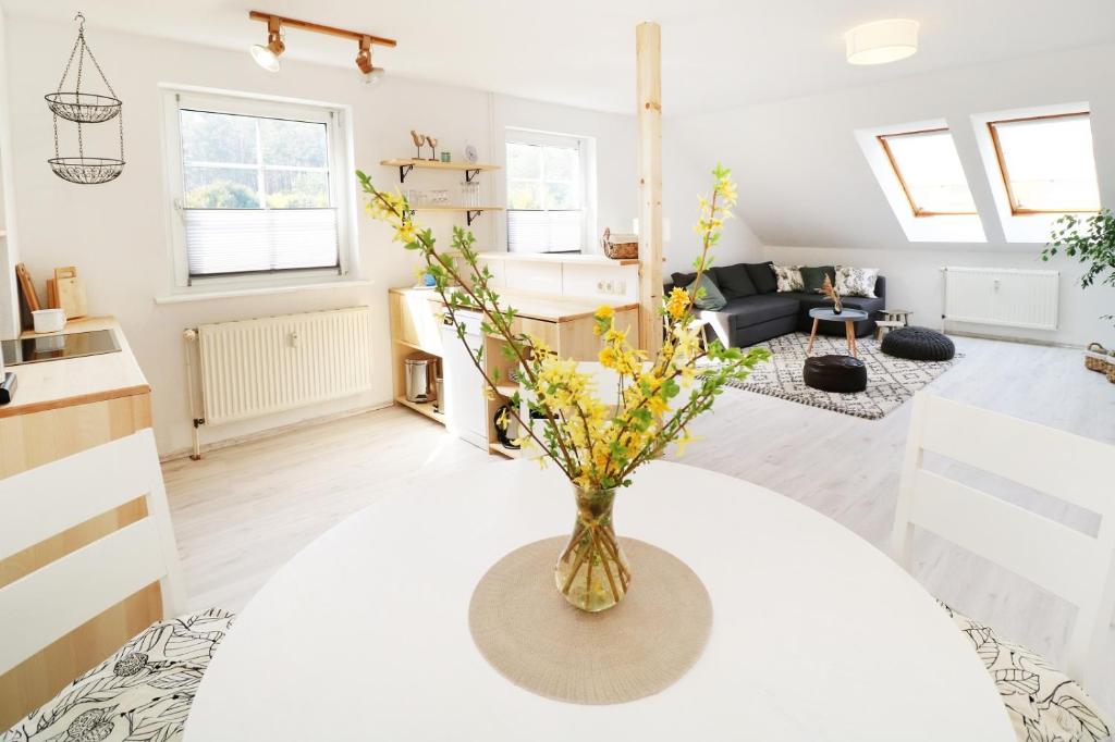 um vaso com flores numa mesa numa sala de estar em Ferienwohnung Gnitzer Auszeit em Lütow