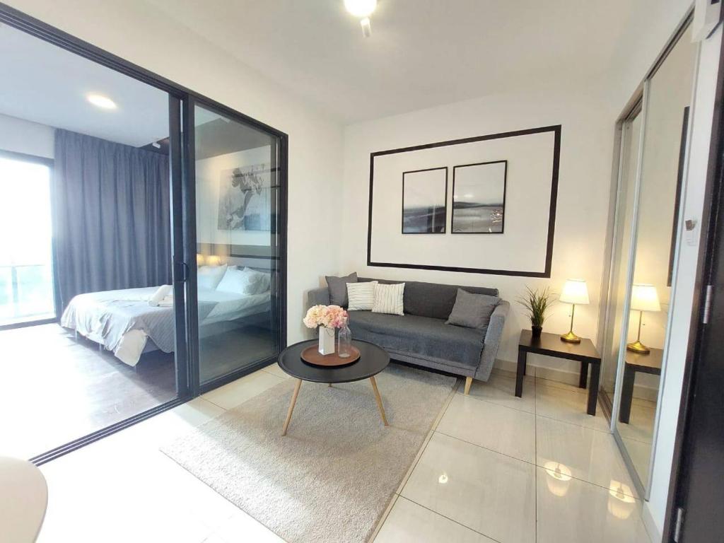 een woonkamer met een bank en een tafel bij Almas Suite Modern Comfy Studio House in Gelang Patah