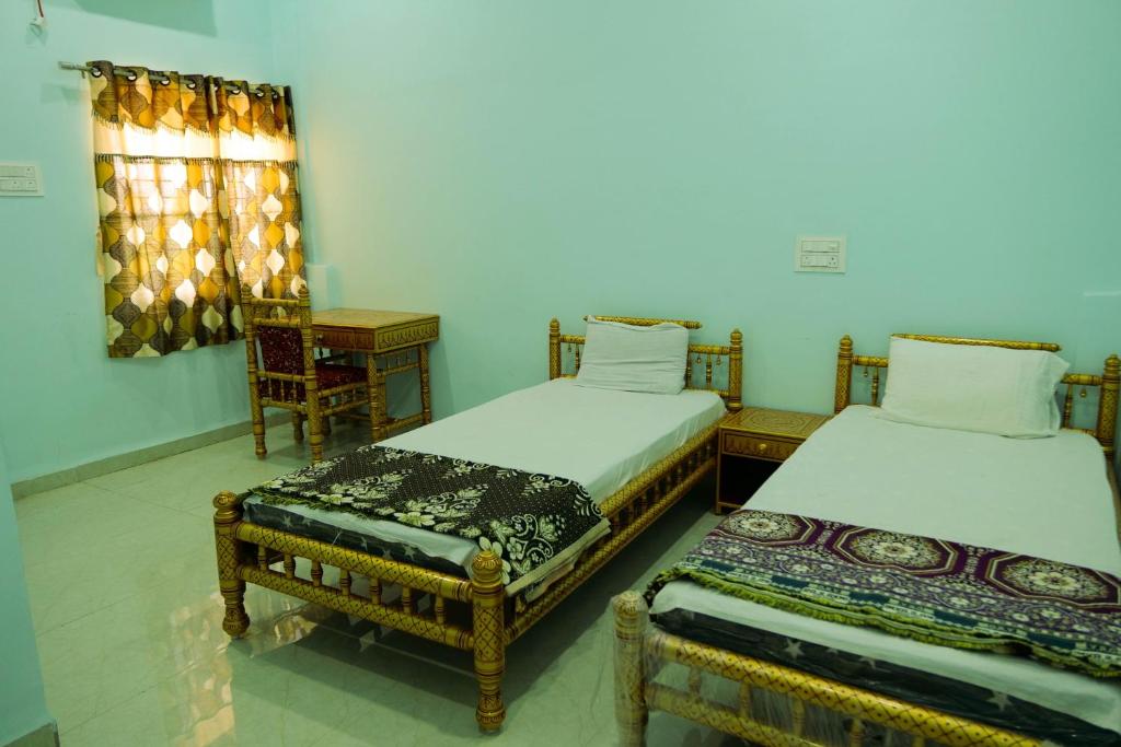 Postelja oz. postelje v sobi nastanitve ISKCON Pandharpur's Chandrabhaga Guest House