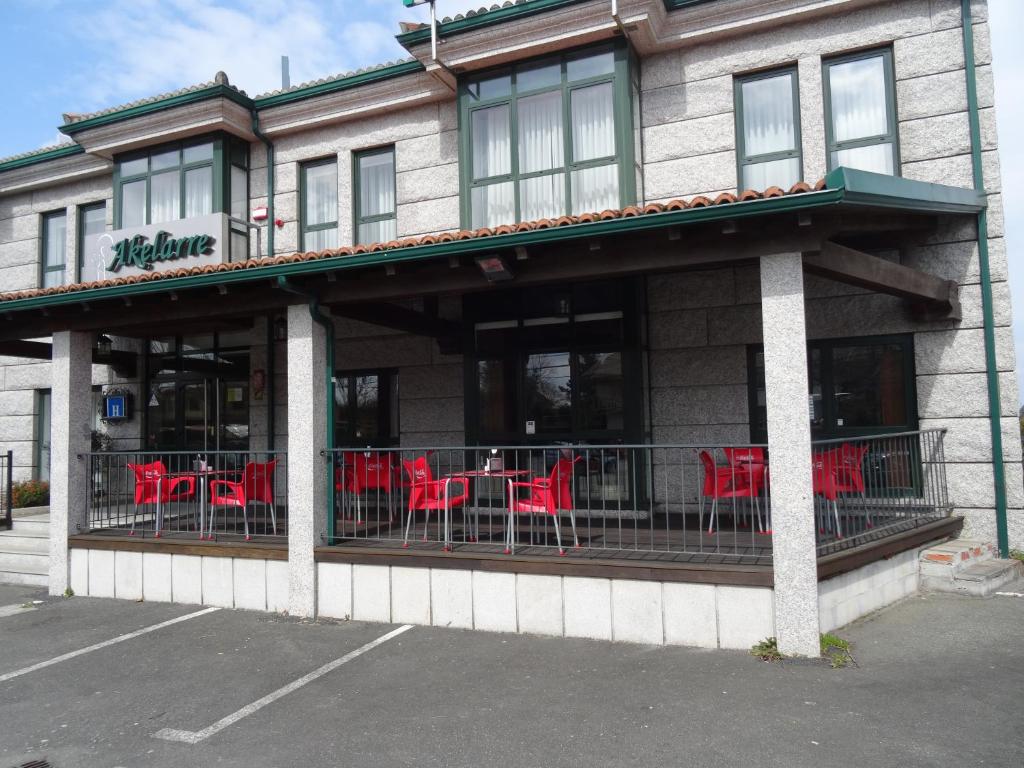 a restaurant with red tables and chairs on a balcony at Hotel Akelarre in Santiago de Compostela