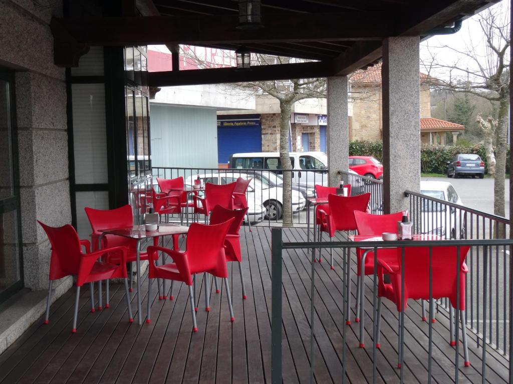 a group of red chairs and tables on a patio at Hotel Akelarre in Santiago de Compostela