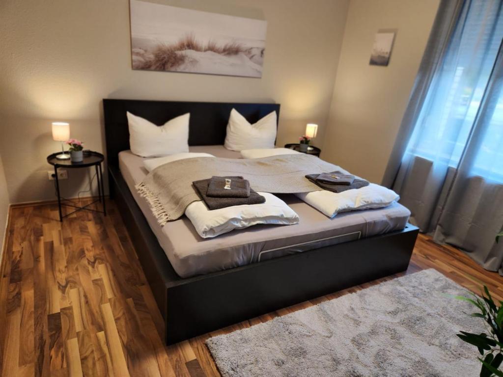 1 dormitorio con 1 cama grande con almohadas blancas en Liro Mönchengladbach en Mönchengladbach