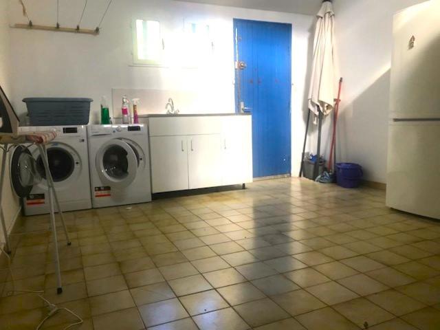 a kitchen with a washer and dryer in a room at Les Lauriers in Limoux