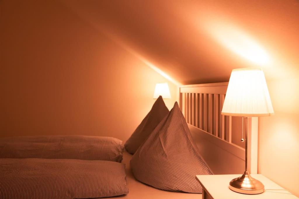 een slaapkamer met een bed en een lamp op een tafel bij Strandnah, familienfreundlich, schön! Hoppetosse am Schönberger Strand in Schönberger Strand