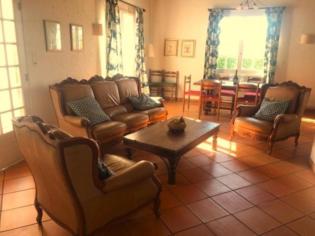 a living room with a couch and chairs and a table at Les Lauriers in Limoux