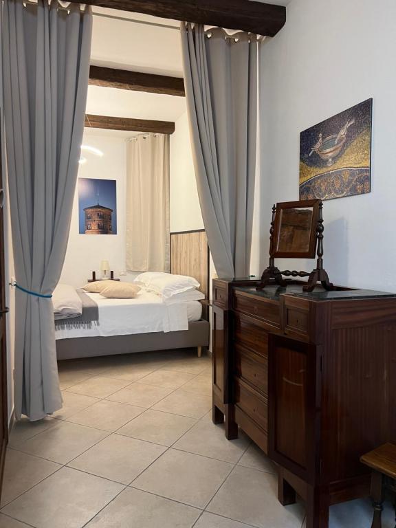 - une chambre avec un lit, une commode et un bureau dans l'établissement Pascoli 21/A, à Ravenne
