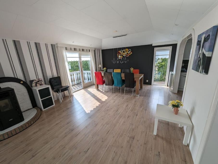 een woonkamer met een bank, een tafel en een tv bij Chalet Anloo, van harte welkom. in Anloo