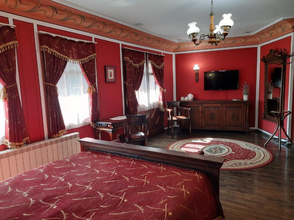 a living room with red walls and a flat screen tv at Family Hotel at Renaissance Square in Plovdiv