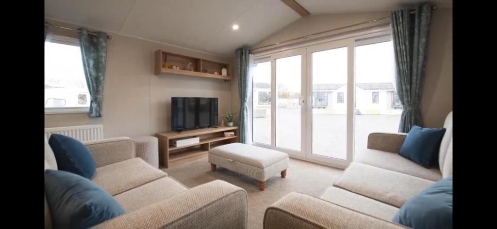 a living room with two couches and a tv at Ultimate serene getaway in East Mersea