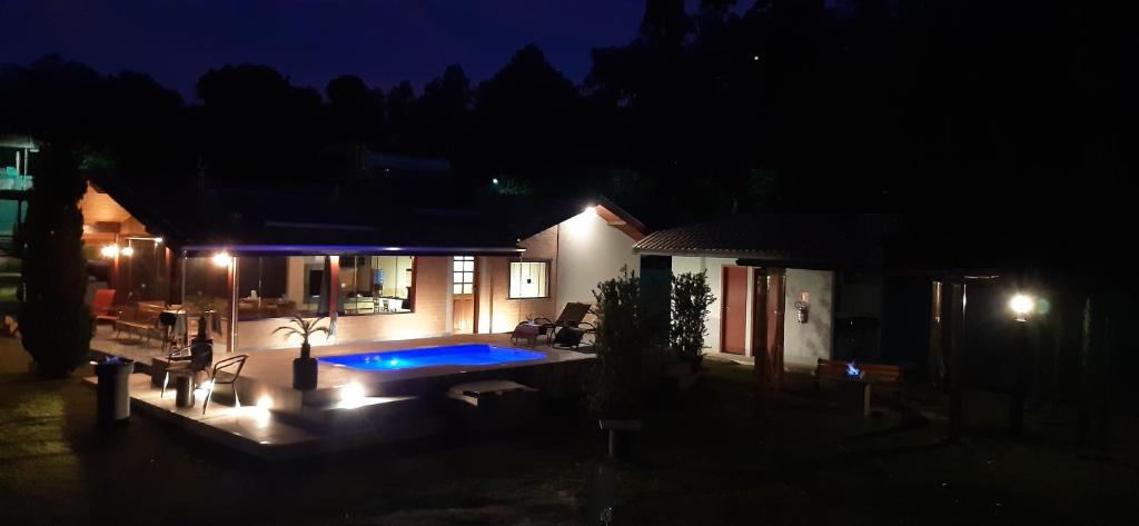 a house with a swimming pool at night at Chalé Lufre in Santo Antônio do Pinhal