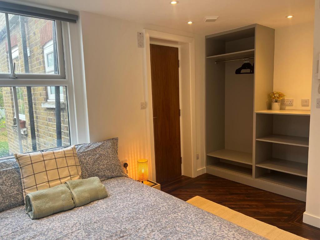 1 dormitorio con cama y ventana grande en Spacious Duplex near Clapham, en Londres