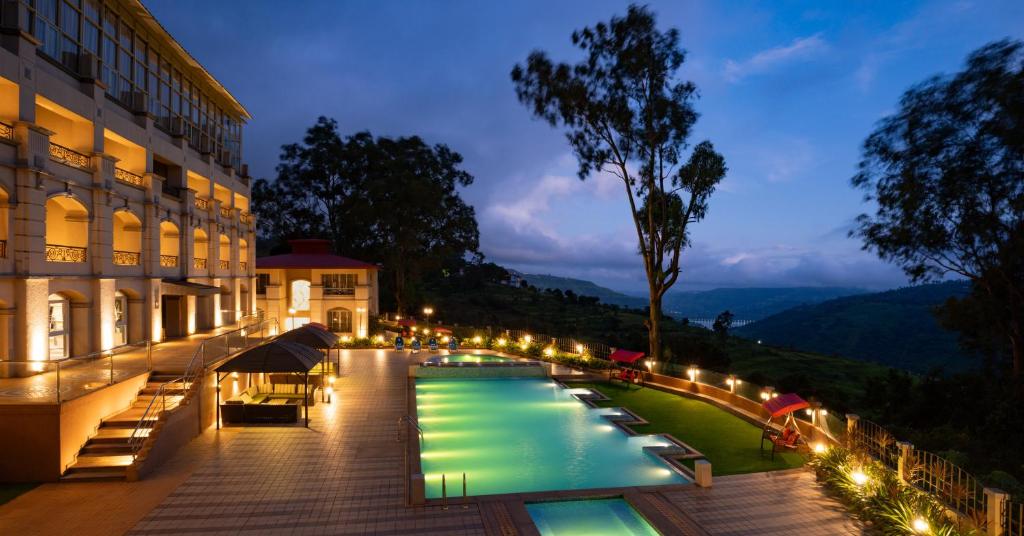 un hotel con piscina por la noche en Grand Victoria The Fern Resort & Spa, Panchgani - Mahabaleshwar, en Panchgani