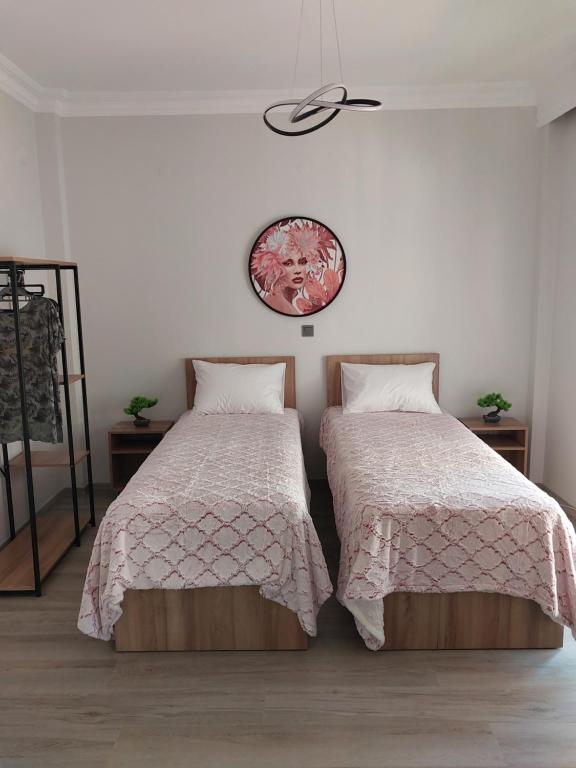 een slaapkamer met 2 bedden en een klok aan de muur bij AniBo studios and apartments ZERO POINT 46 in Thessaloniki