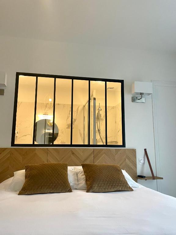 a bedroom with a large window above a bed at LA TOUR AUX CRABES près de la plage in Dieppe