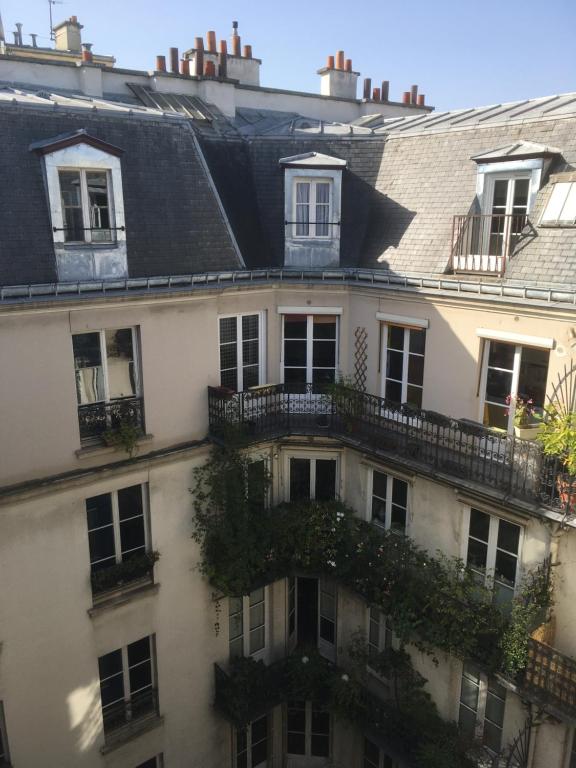 ein Apartmenthaus in Paris mit Fenstern und Balkonen in der Unterkunft Studio 6 in Paris