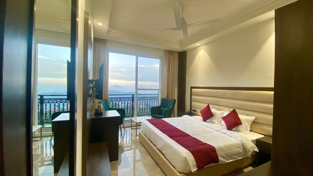 een slaapkamer met een bed, een bureau en een balkon bij LUXE RESORTS - CENTRALLY HEATED AIR CONDITIONED HOTEL in THE HEART OF KASAULI in Kasauli