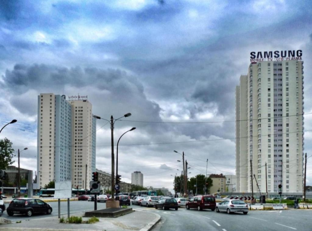 two tall buildings on a busy city street with cars at BeautifulParis18 in Paris