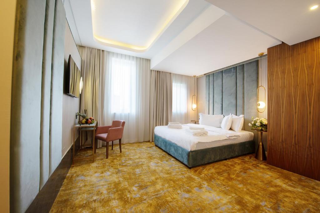 une chambre d'hôtel avec un lit et une chaise dans l'établissement Yasu Luxury Rooms, à Bucarest