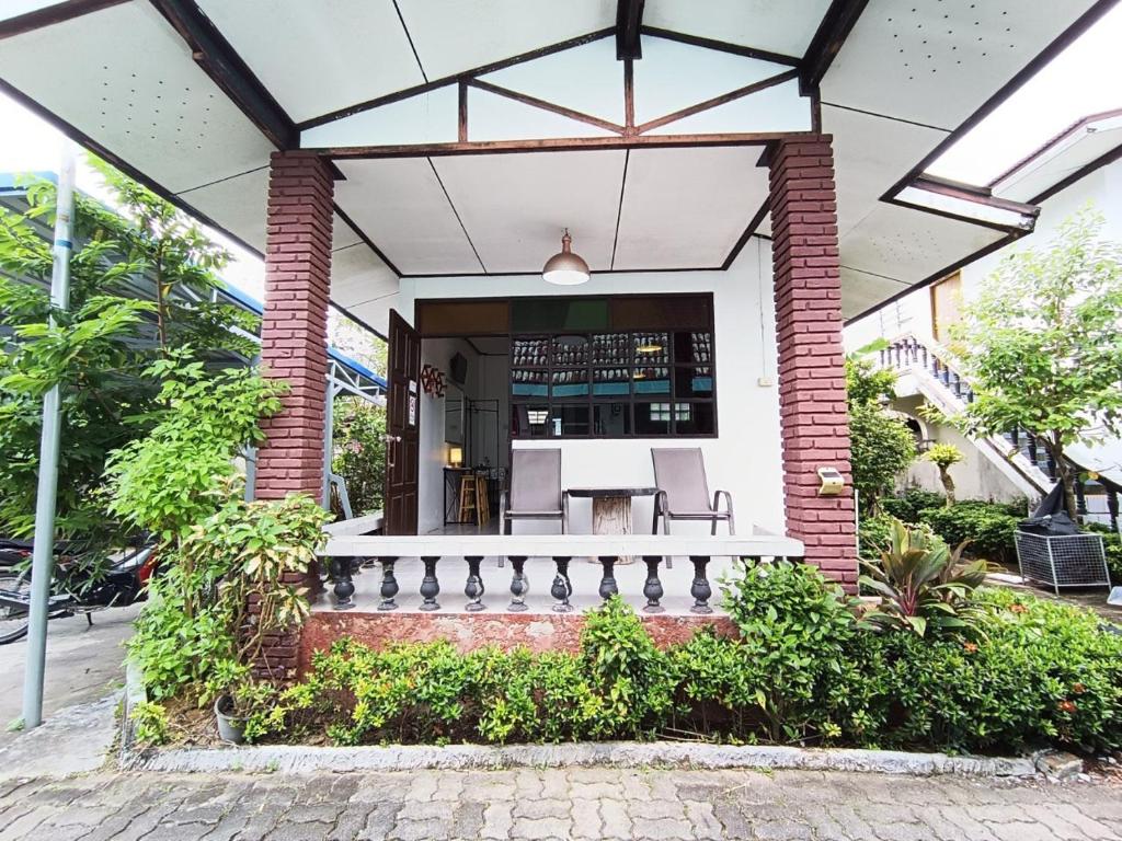 une maison avec une terrasse couverte et un bar. dans l'établissement THE NAIYANGHOUSE, à Nai Yang Beach