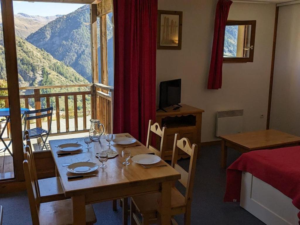 uma sala de jantar com uma mesa e vista para uma montanha em Appartement Orcières Merlette, 2 pièces, 4 personnes - FR-1-262-160 em Les Estaris