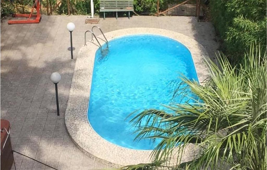 une grande piscine bleue dans une arrière-cour dans l'établissement Pet Friendly Home In Roma With House A Panoramic View, à Rome