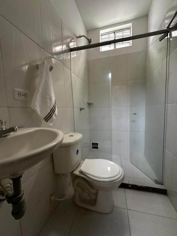 y baño con aseo, lavabo y ducha. en Apartamentos sin fronteras, en Leticia