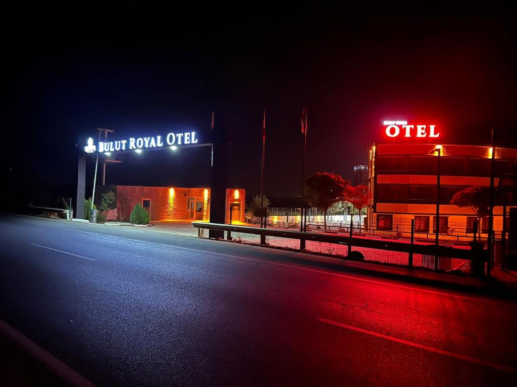 an empty street at night with a neon sign at Bulut Royal Otel 