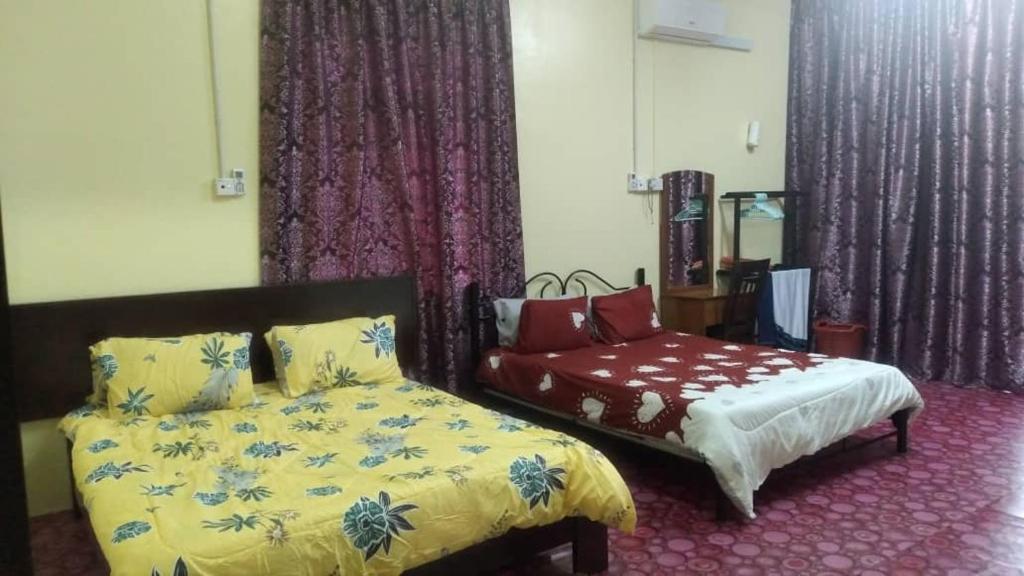 a bedroom with a bed and a chair in it at Tina Homestay Budget in Ketereh