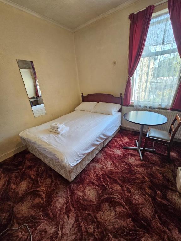 um quarto com uma cama e uma mesa em The 23 em Londres