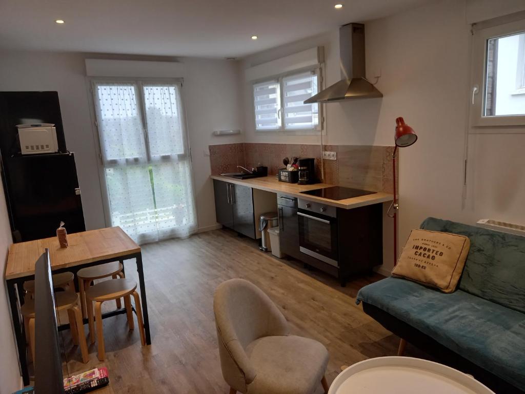 uma cozinha e sala de estar com um sofá e uma mesa em Aux Portes de Brest em Le Relecq-Kerhuon