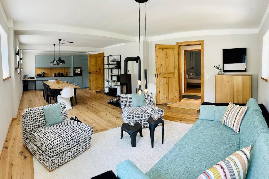 a living room with a blue couch and chairs at Traumurlaub auf dem Brandmanngut in Marquartstein