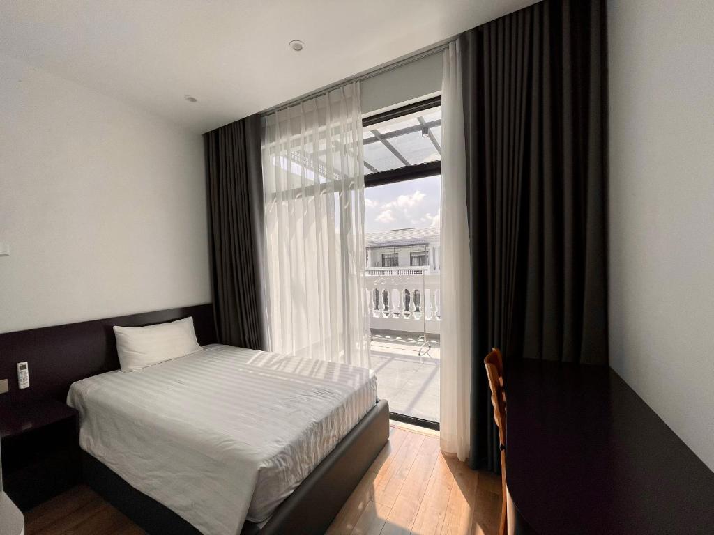 ハイフォンにあるThe LuxHomes Apartment & Homestay HD106のベッドと大きな窓のある寝室