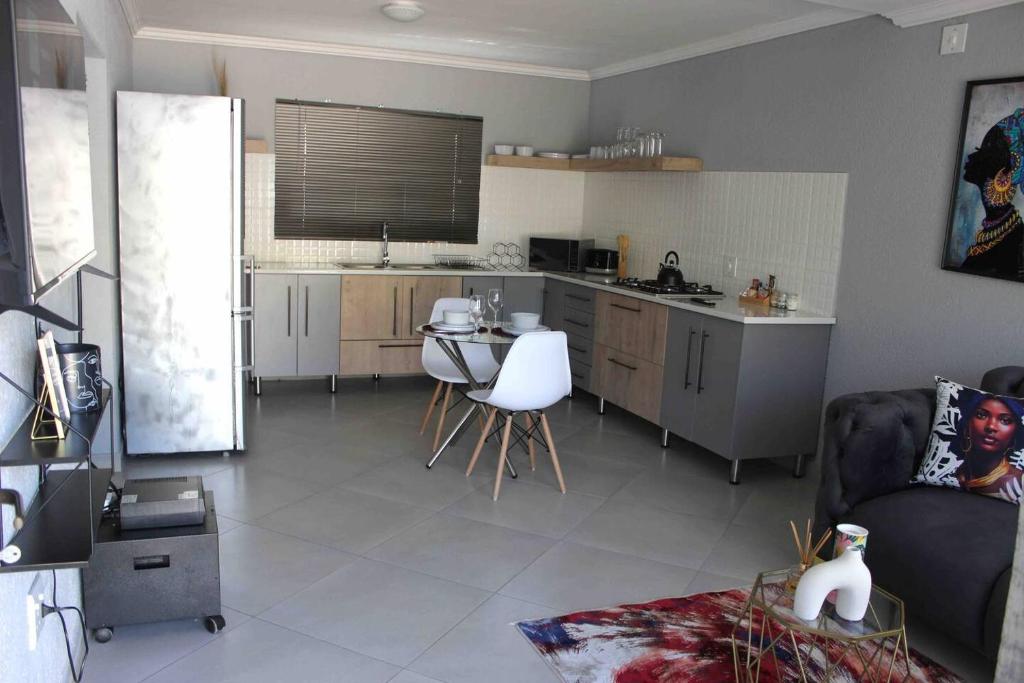 a kitchen and living room with a couch and a table at Tranquility at Homely Escape in Phalaborwa