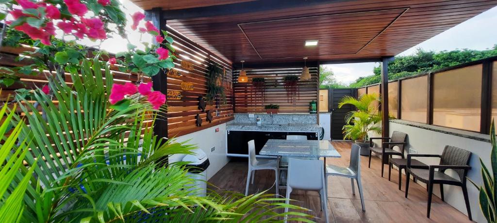 a patio with a table and chairs and a fireplace at Pipa Ubaia 219 com solarium in Pipa