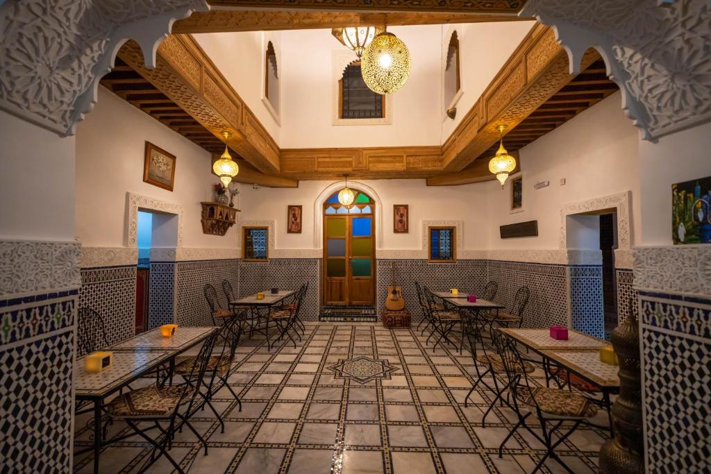 un restaurante con mesas y sillas en una habitación en Riad Tafoukt Fes, en Fez