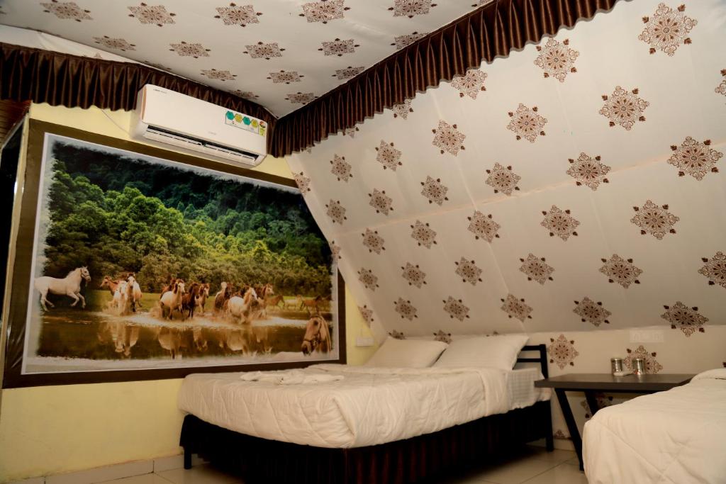 a bedroom with two beds and a painting on the wall at Rama Hills Unity Resort in Lāchharas
